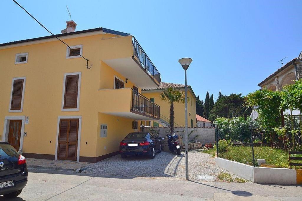 a yellow house with a car parked in front of it at Apartments Agata in Novigrad Istria
