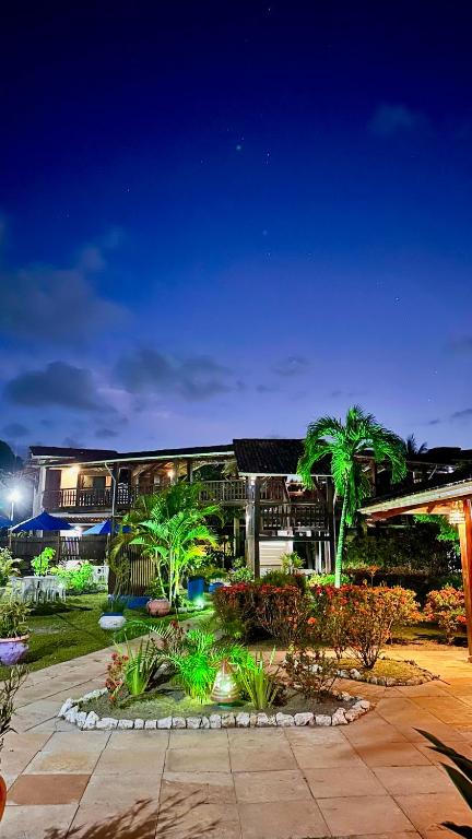 a building with palm trees in front of it at Pousada Meu Sossego in Barra Grande