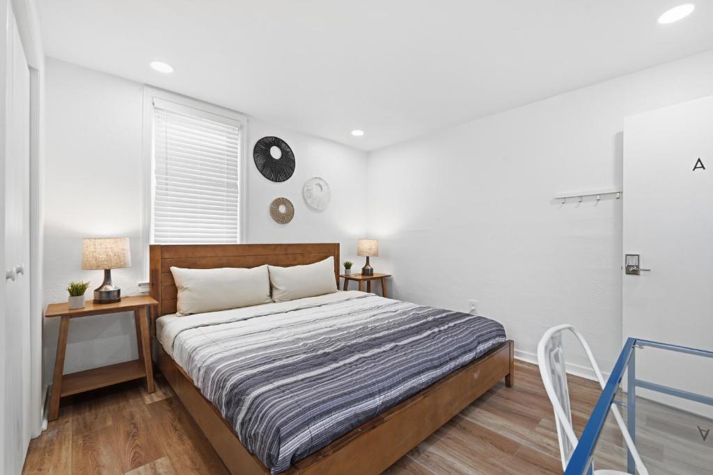 a bedroom with a bed and two tables and a window at Dormont, Pittsburgh !A Spacious and Modern Private Bedroom with Shared Bathroom in Pittsburgh