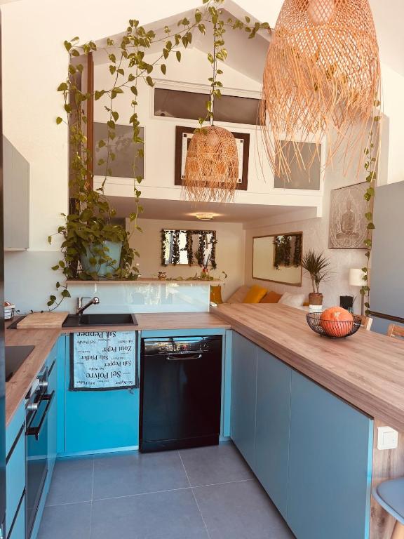 a kitchen with blue cabinets and a wooden counter top at Coeur Créole in Saint Barthelemy