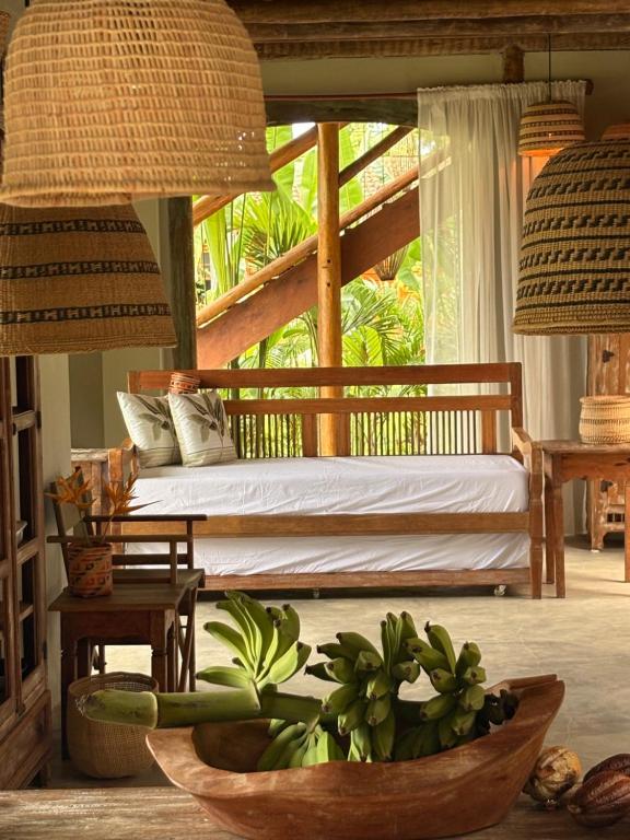 a bedroom with a bed and a bowl of plants at Casa Felina in Ilha de Boipeba