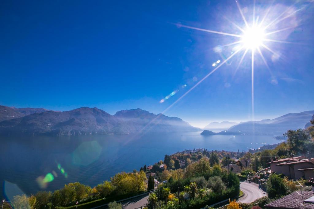 a view of a lake with the sun in the sky at Casa Laura Apt. 6 in Menaggio