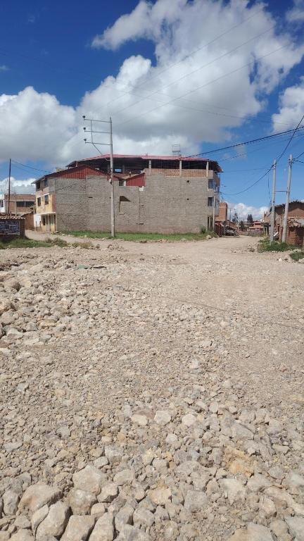 a building in the middle of a dirt field at Hospedaje Rumichaca in Cusco