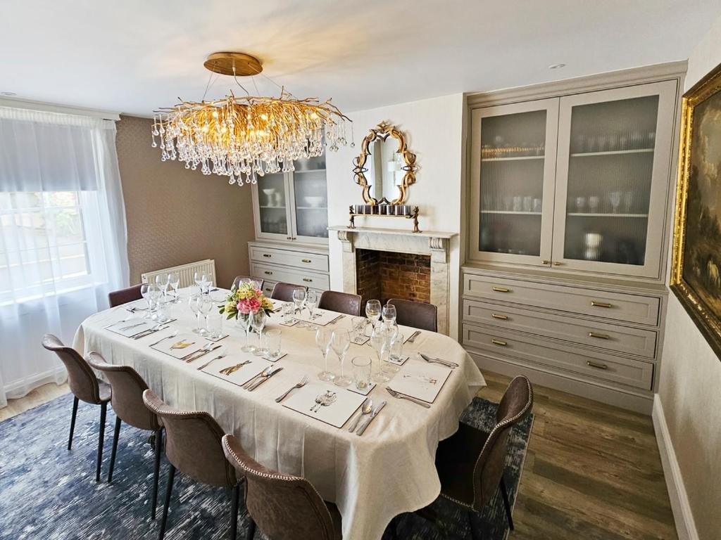 a dining room with a table with chairs and a chandelier at Landguard - Yarmouth in Yarmouth