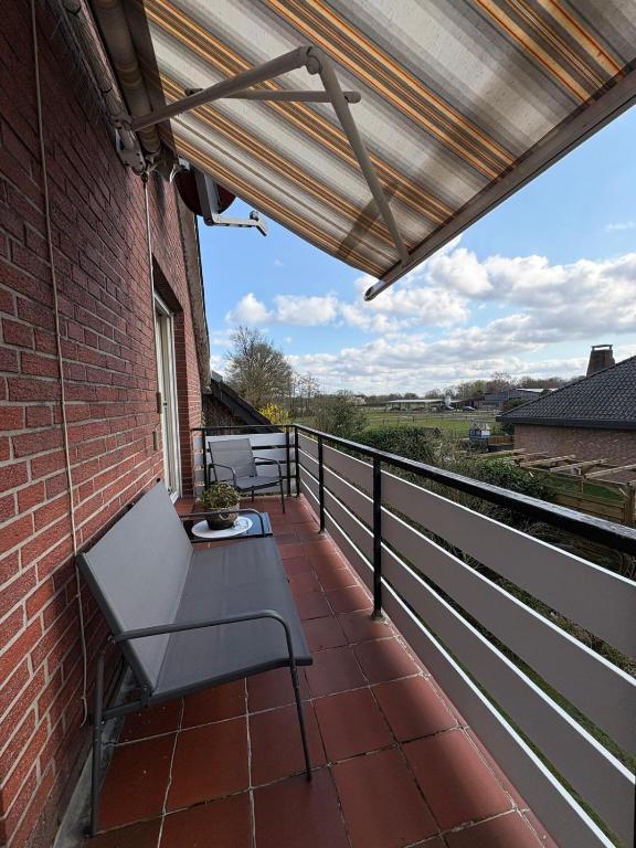 a patio with a bench on a brick building at Ferienwohnung zum Pferdeblick in Bad Bentheim