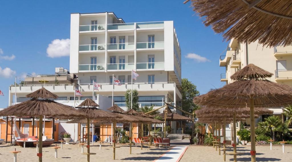 a hotel with straw umbrellas on the beach at Igea Spiaggia Home Holiday in Bellaria-Igea Marina