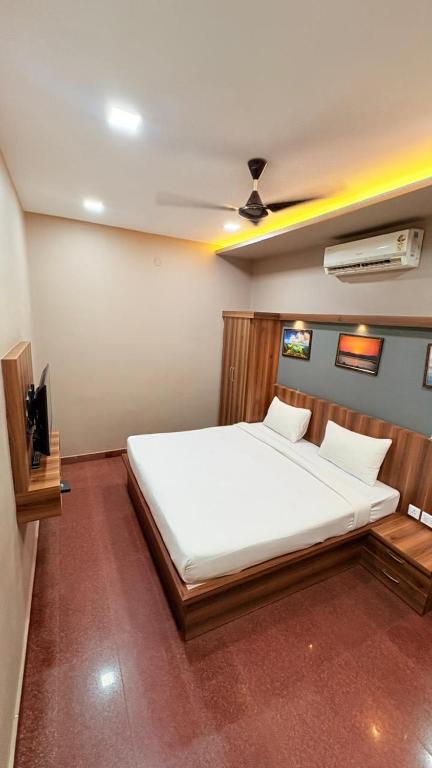 a bedroom with a large white bed and a tv at Century Regency in Cochin