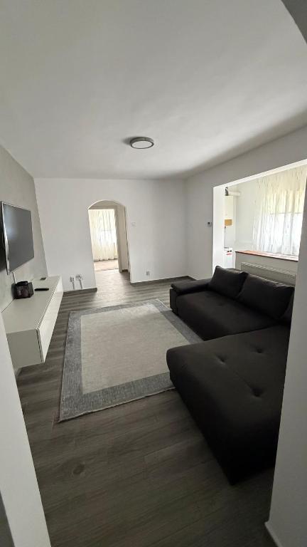 a living room with a black couch and a table at Luxury Lion Crib2 in Bacău