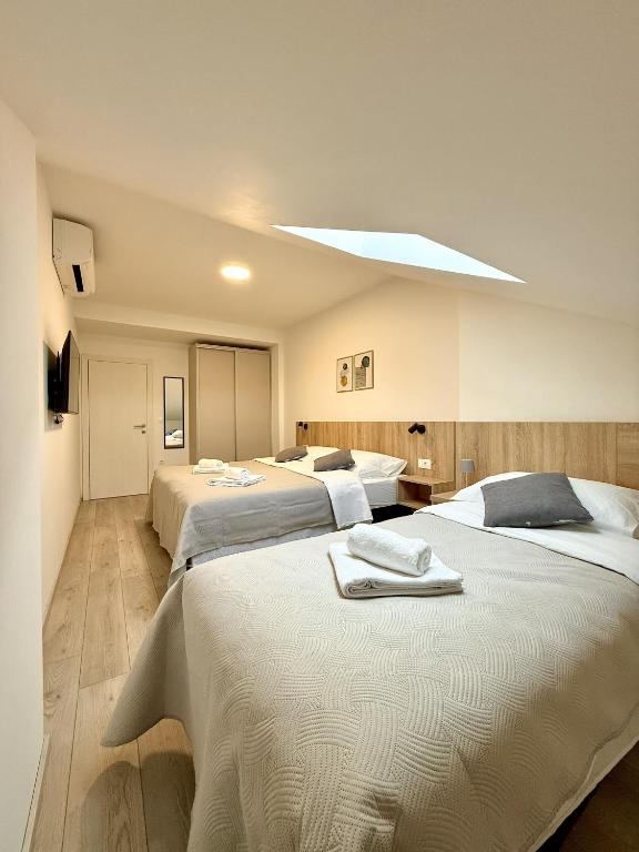 a bedroom with three beds with towels on them at Cloud9 Airport Suites in Močići