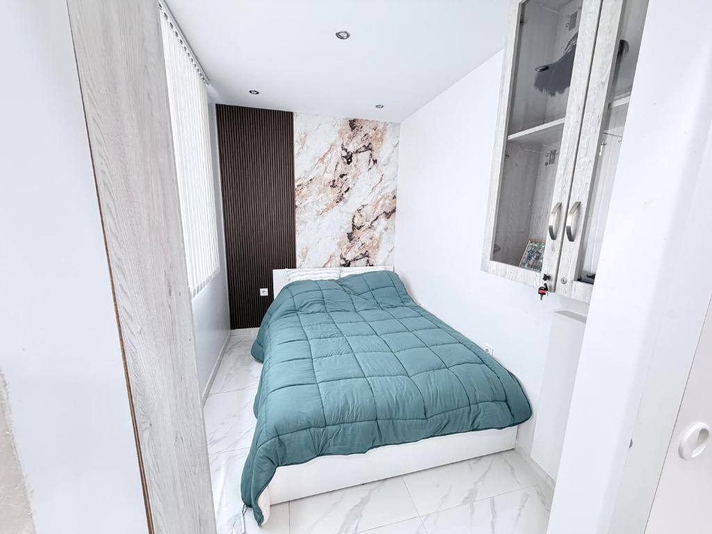 a small bedroom with a green comforter on a bed at Студио за гости АВАНГАРД in Gabrovo