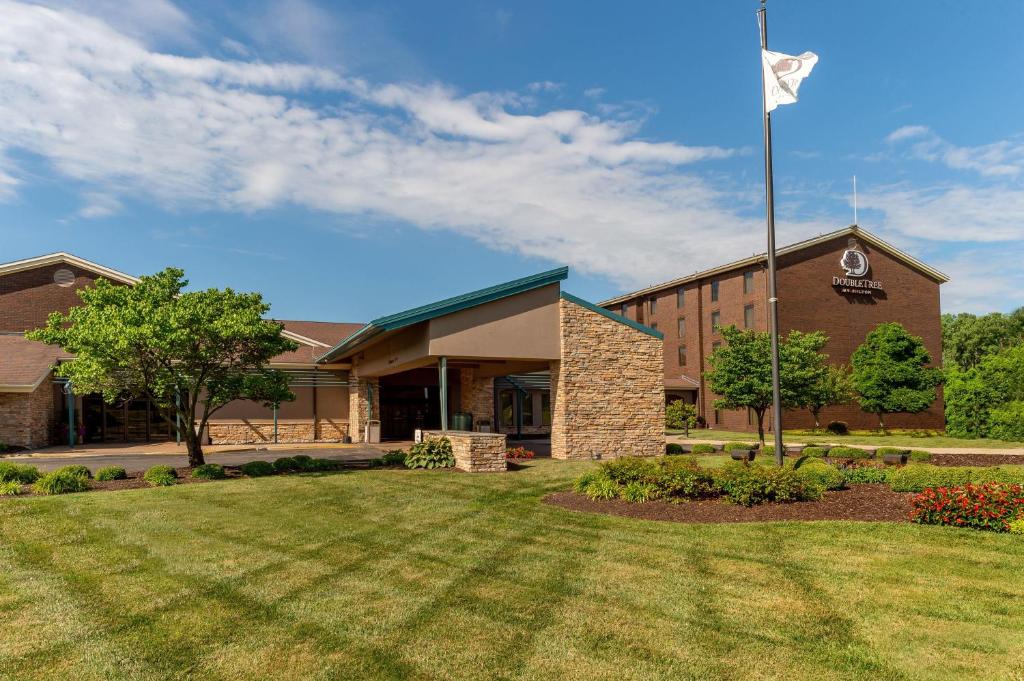 a building with a flag in front of a yard at DoubleTree by Hilton Collinsville/St.Louis in Collinsville
