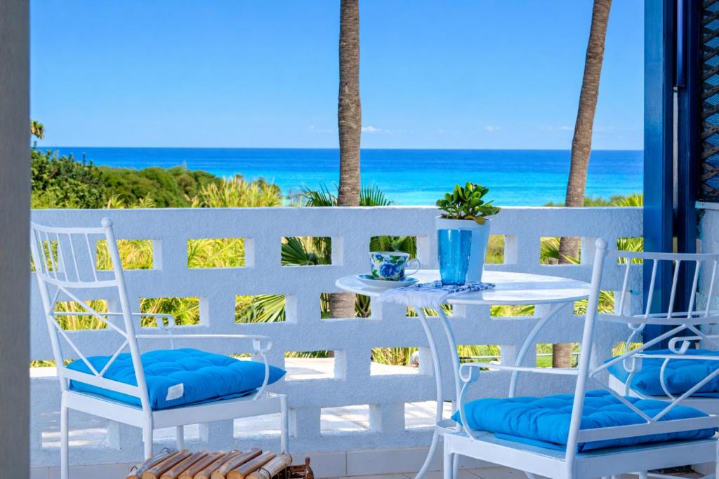 a table and chairs on a balcony with the beach at Spitaki by the Sea in Paralimni