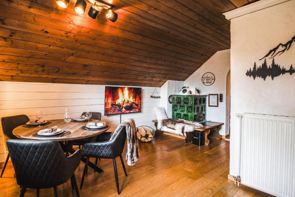 a living room with a wooden ceiling and a table and chairs at MountainView Lodge - Sauna, Balkon, 300 m zur Gondel in Sankt Oswald