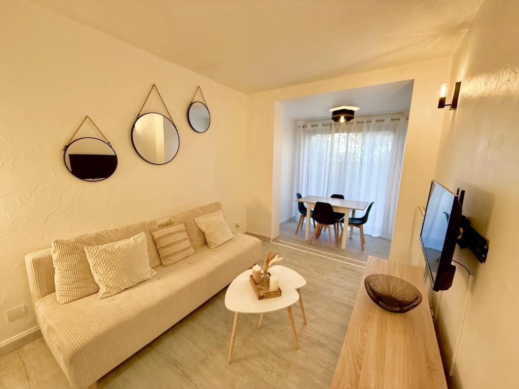 a living room with a couch and a table at Le Cosy du Lagon bleu in Fréjus