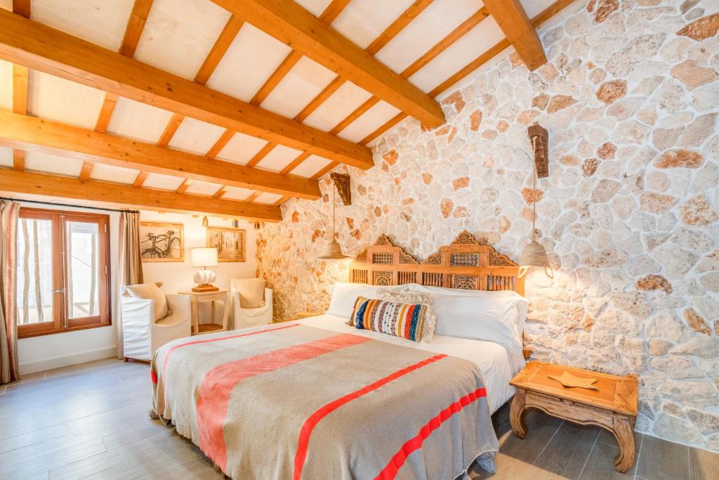 a bedroom with a bed and a stone wall at Calma Hotel in Ciutadella