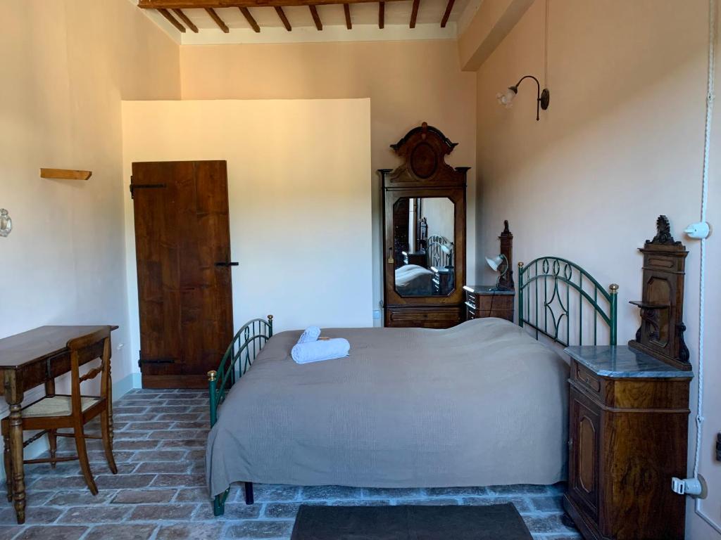 a bedroom with a bed and a table and a mirror at Palazzo Bruschi in Pergola