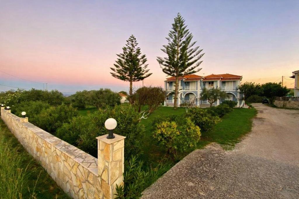 a house with a stone fence in front of it at Stelios Studios - Zante Seaview Nests in Tragaki