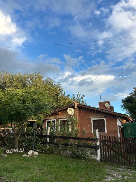 a brick house with a fence in front of it at Cabañas Kidamalau in Merlo