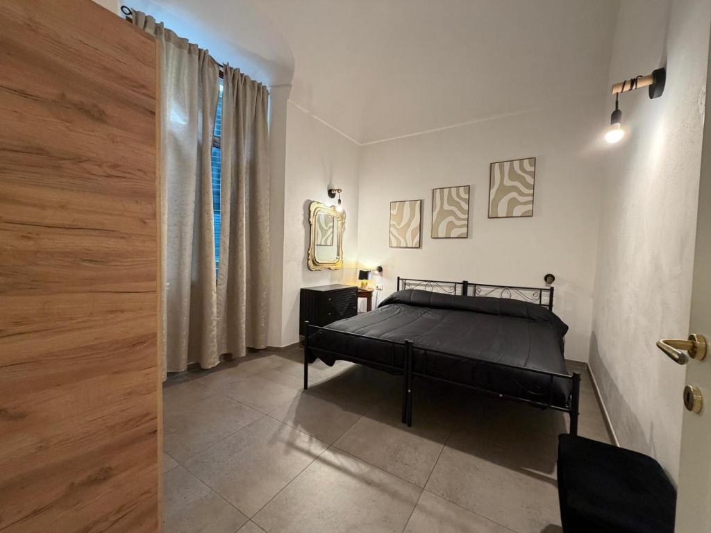 a bedroom with a black bed and a window at A ca' de Lisetta in Albenga