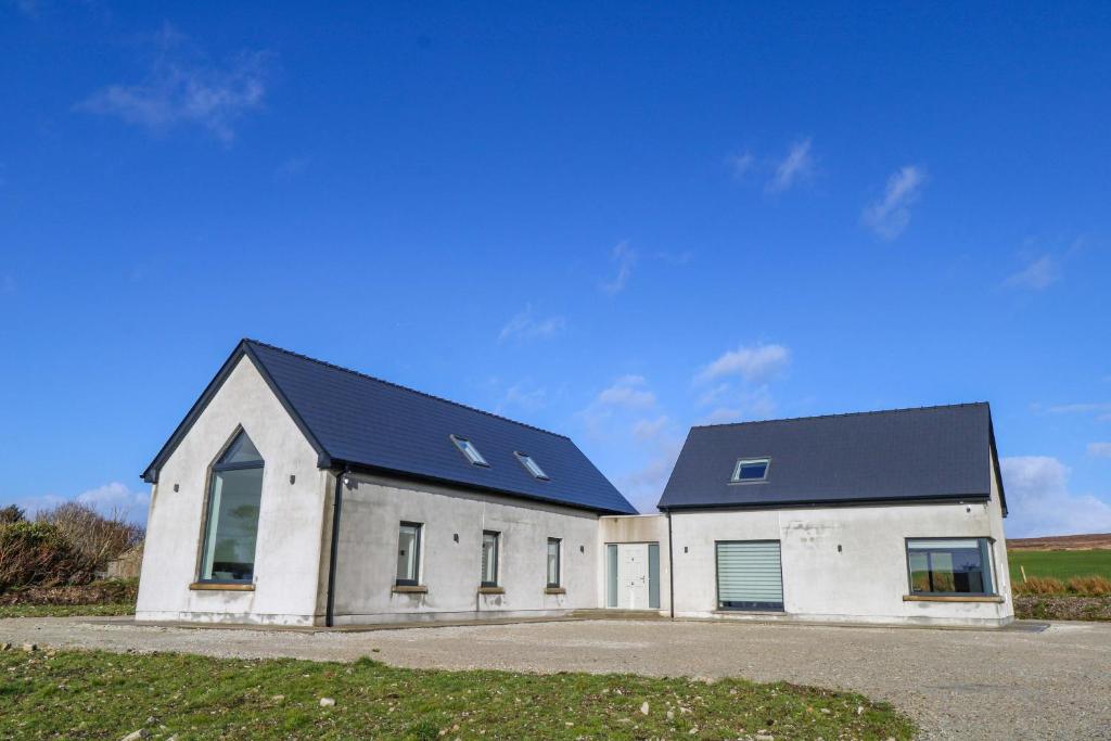 a large white building with a black roof at An Tobar in Ballina