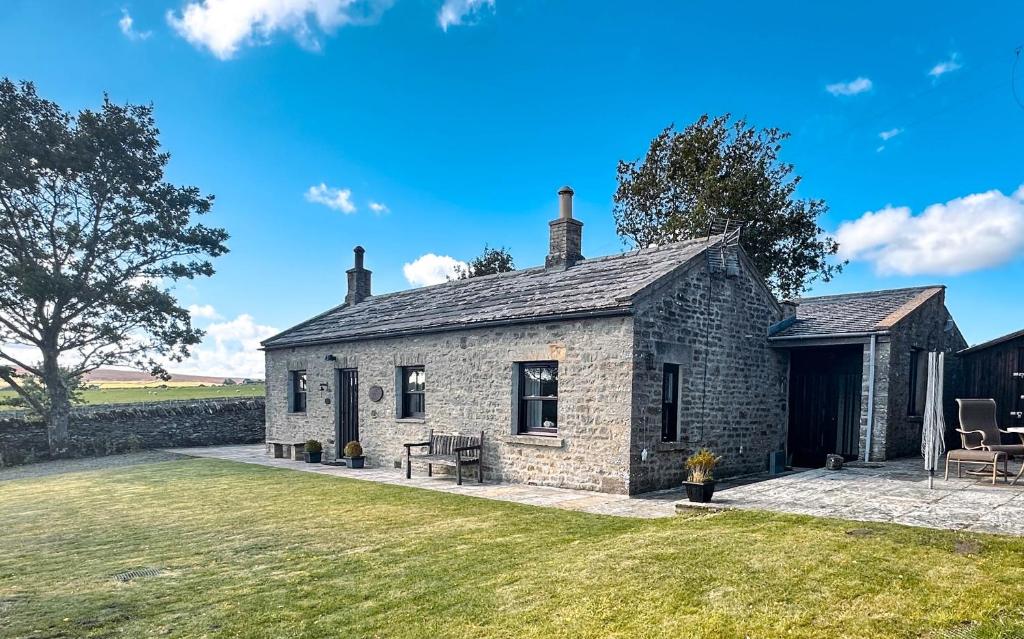 an old stone cottage with a grass yard at Rubbing House in Marske