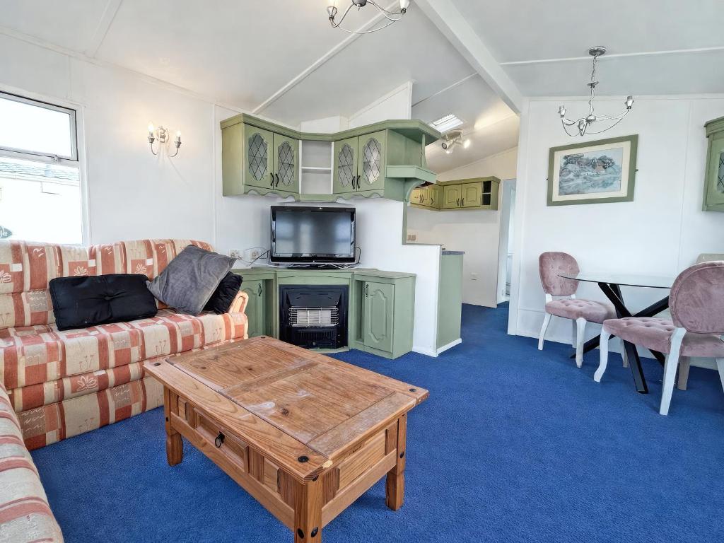 a living room with a couch and a table at Minster - Uk51005 in Eastchurch
