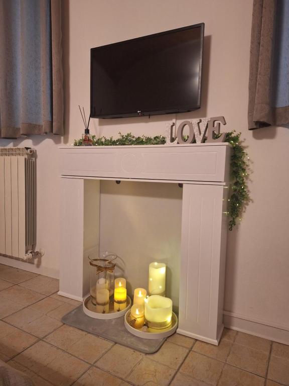 a fireplace with candles and a flat screen tv on top at Gioberti in Casale Monferrato