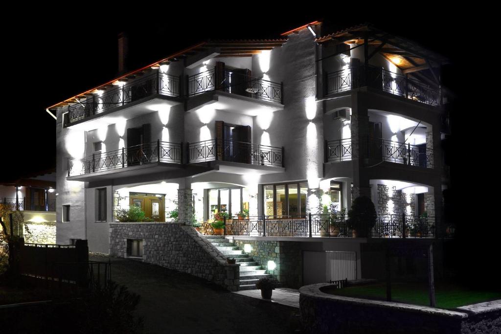 a large white building with lights on it at night at Artemis Traditional Guesthouse in Levidhion