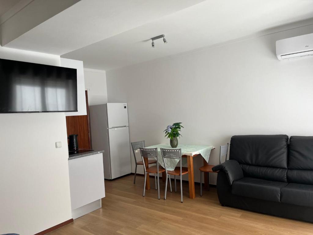a living room with a black couch and a table at Apartamentos e quartos Primorosa in Nazaré