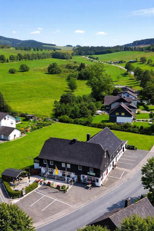 Luftaufnahme eines Gebäudes mit Tennisplatz in der Unterkunft Gasthof Sonnental in Winterberg