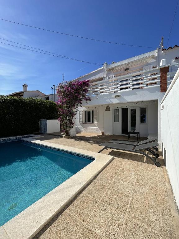 a villa with a swimming pool in front of a house at House close to the beach of Punta Prima in Punta Prima
