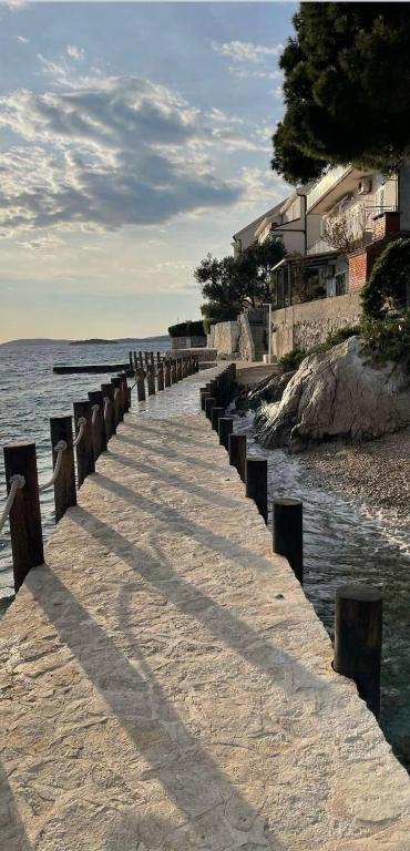 a long walkway leading to the water on a beach at Apartments Jareb in Tribunj