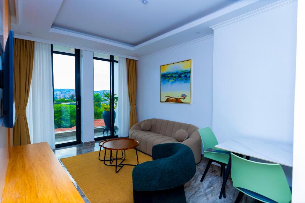 a living room with a couch and a table and chairs at T-Stone Apartments Hotels -Kigali in Kigali