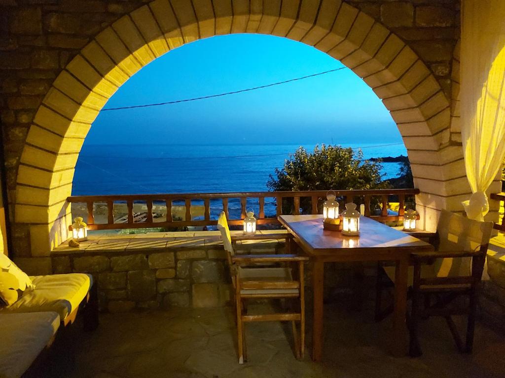 a table with chairs and a view of the ocean at Almyra apt in Mani in Kotrónion