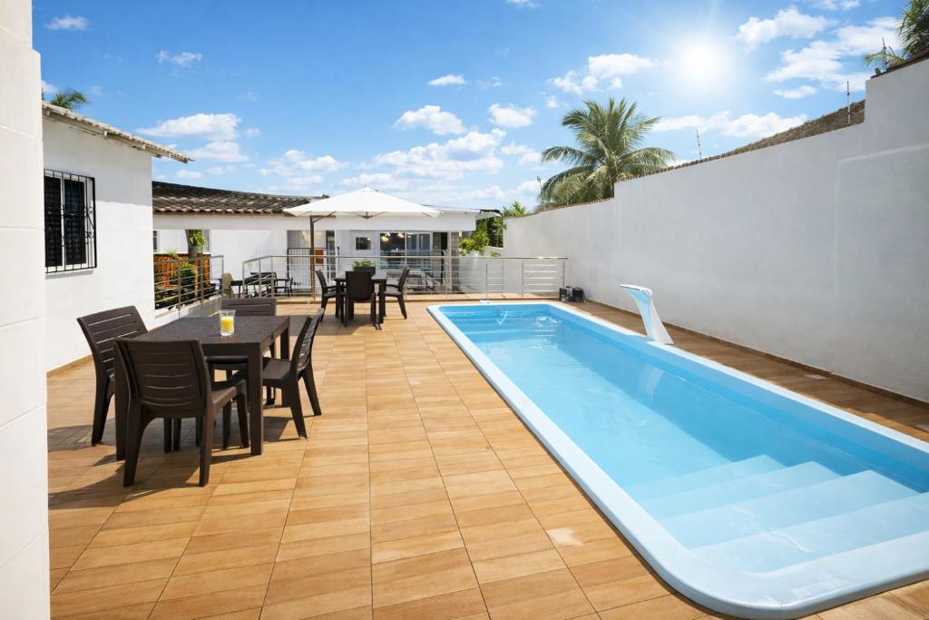 a patio with a swimming pool and a table and chairs at Casarão Figueiredo in Presidente Figueiredo