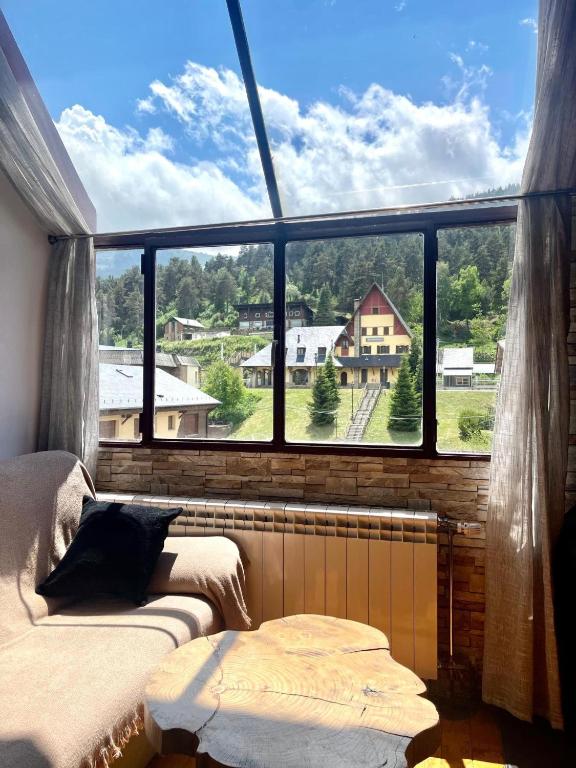 a room with two beds and a large window at Dúplex acogedor en La Molina- 8 Pax in La Molina