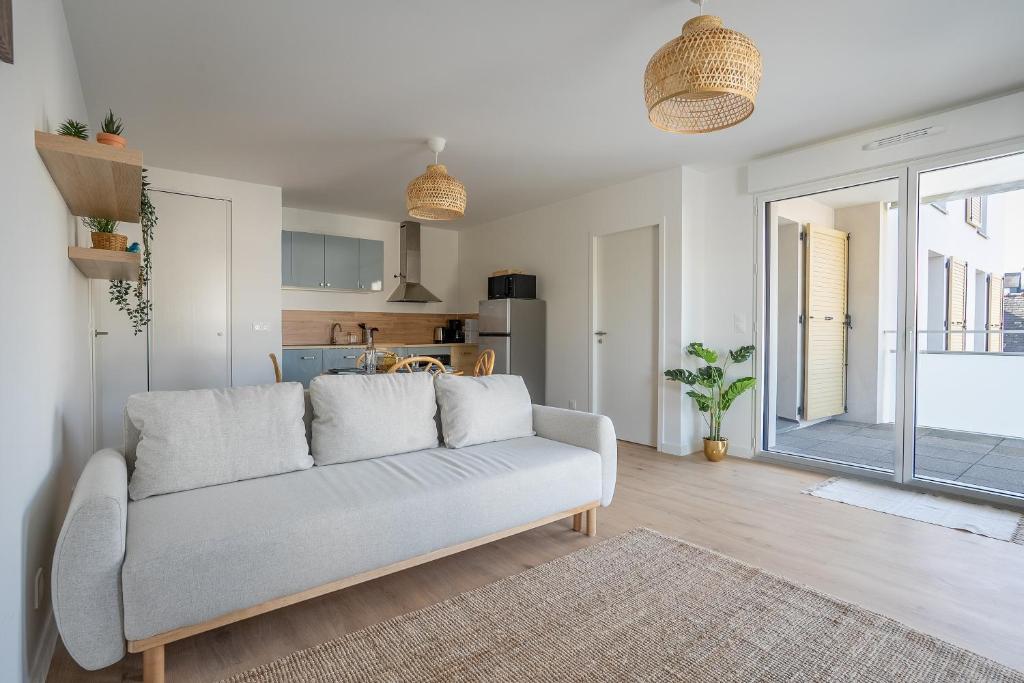 a living room with a couch and a kitchen at L'Escale d'Erdeven - En centre-bourg in Erdeven