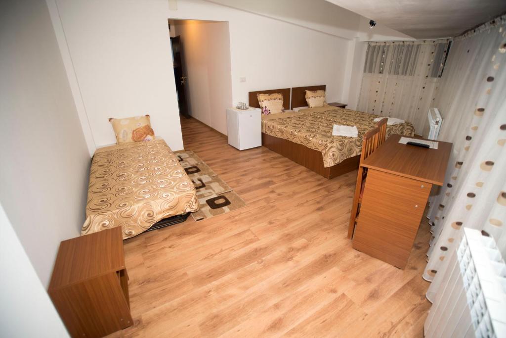 Habitación pequeña con 2 camas y suelo de madera. en Hostel Ruxandra en Focşani