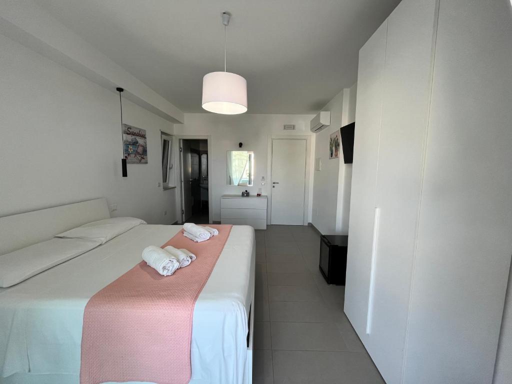 a hotel room with two beds and a pink blanket at La Maison de Marcelle in Tropea