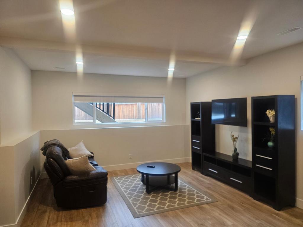 a living room with a couch and a table at Modern Private Suite Fast WiFi Parking Quiet Stay in Prince George