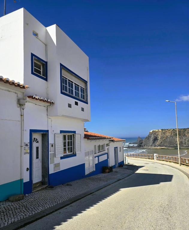 a white and blue building on the side of a road at Sol da Praia in Odeceixe