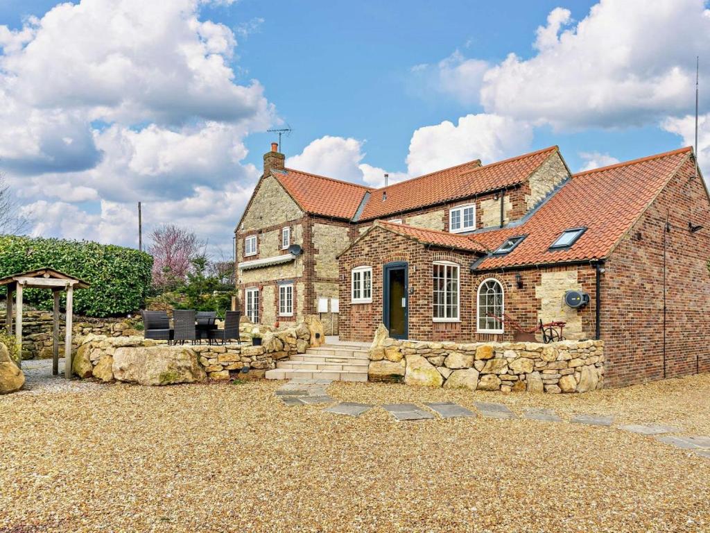 an old stone house with a stone wall at 5 Bed in Leeds oc-91355 in Sherburn in Elmet