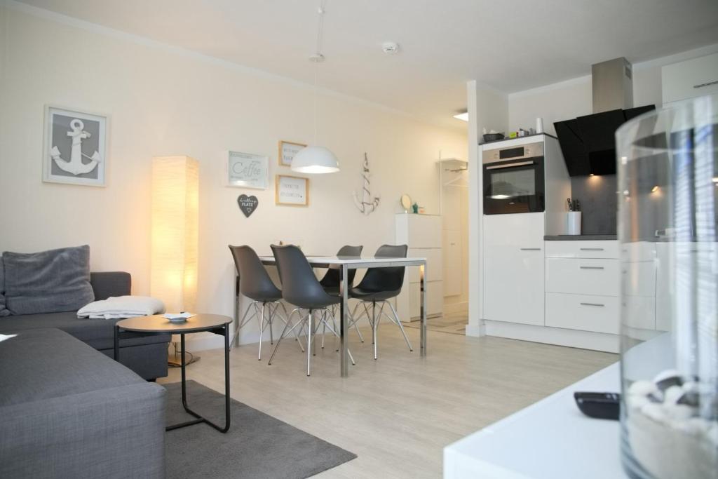 a living room and kitchen with a table and chairs at Haus Titania App 6 inkl WLAN in Grömitz