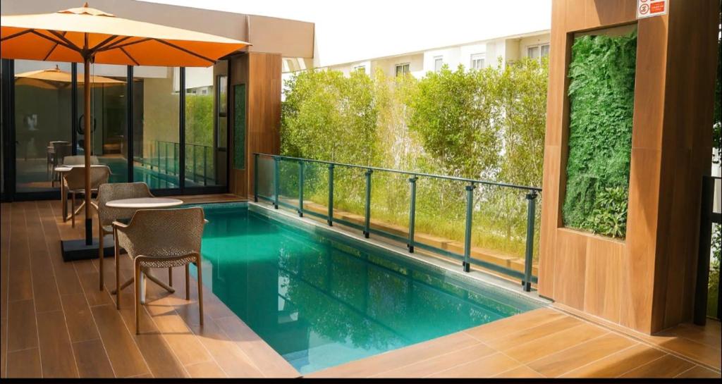 a swimming pool with a table and chairs and an umbrella at Ijou gdena in Sidi Daoud