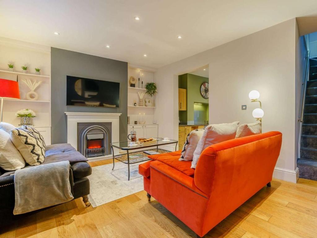 a living room with an orange couch and a fireplace at 2 Bed in Harrogate oc-hh029 in Harrogate