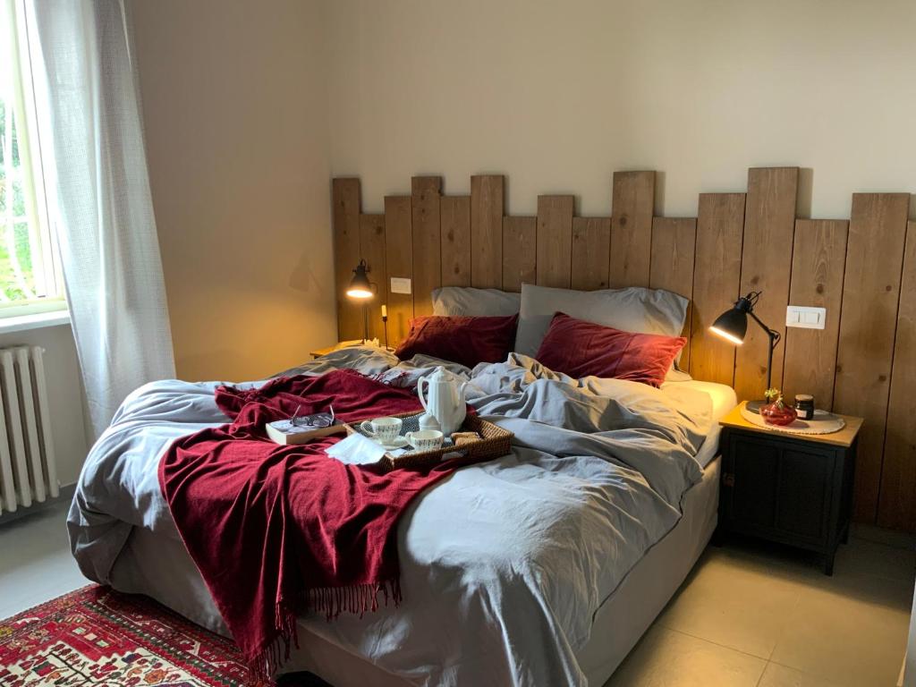 a large bed with a wooden headboard in a bedroom at Amatacasa Villa Rosa in Melfi