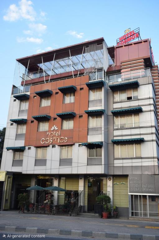 a tall building with a sign on top of it at Hotel Cosmos in Lucknow