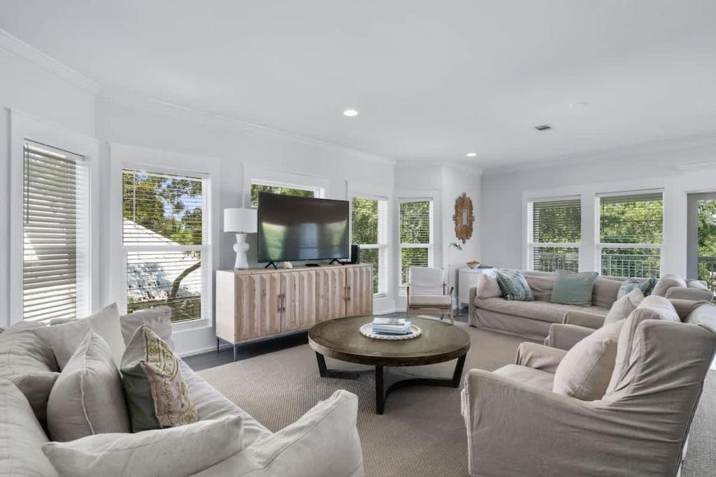 a living room with white furniture and a flat screen tv at 80 Blue Sky in Santa Rosa Beach