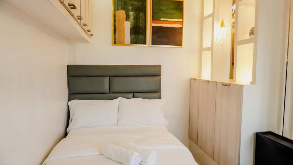 a small bedroom with a bed with white sheets at Corner Studio w Wi-Fi CasaMira Labangon in Cebu City