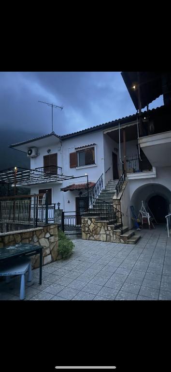 a house with stairs and a building with a patio at Πάροδος Νικολάου Σταθούση in Leonidio